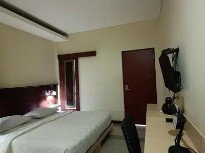 a bedroom with a bed and a television in it at Keola Hotel Legian in Legian