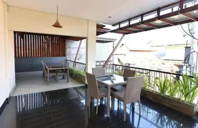 a patio with a table and chairs on a balcony at Keola Hotel Legian in Legian