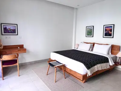 a bedroom with a bed and a desk and a chair at LINDT - Bali Invest Club in Dalung