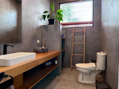 a bathroom with a sink and a toilet and a mirror at LINDT - Bali Invest Club in Dalung