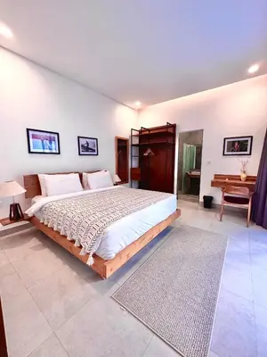 a bedroom with a large bed and a desk at LINDT - Bali Invest Club in Dalung