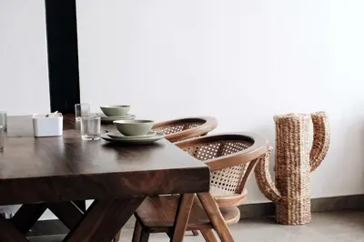 a dining room table with two chairs and a wooden table with cups at TropicalLoft With Ocean View From Rooftop -RARE! in Canggu