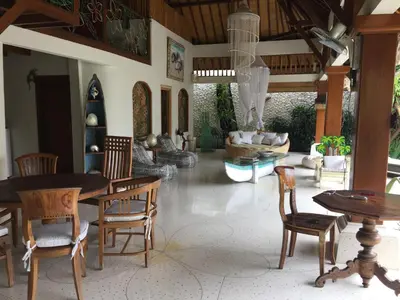 a living room with a table and chairs and a couch at Villa Domus De Janas in Seminyak