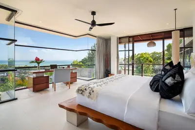 a bedroom with a bed and a view of the ocean at The Lookout Villa Jimbaran By Island Escape in Jimbaran