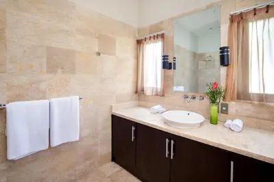 a bathroom with a sink and a large mirror at The Lookout Villa Jimbaran By Island Escape in Jimbaran