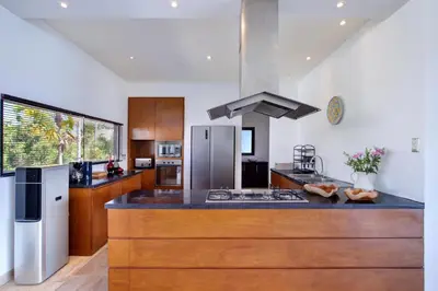 a kitchen with a counter top with a stove top oven at The Lookout Villa Jimbaran By Island Escape in Jimbaran