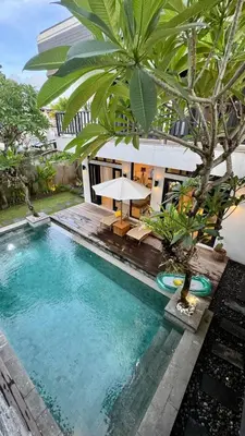 a pool with a table next to a building at Solaris Private Villa Club Residence Canggu in Canggu