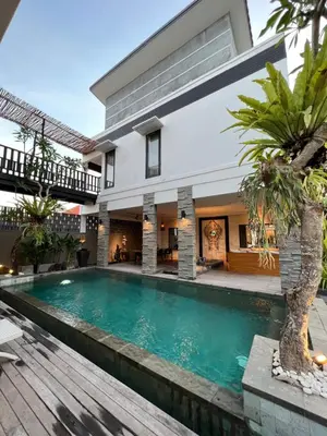 a swimming pool in front of a house at Solaris Private Villa Club Residence Canggu in Canggu