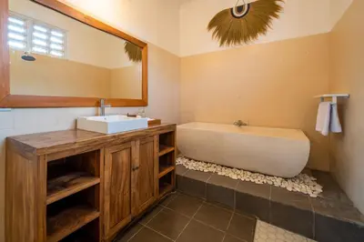 a bathroom with a tub and a sink and a mirror at 2 bedroom Balinese private pool villa in Seminyak in Seminyak