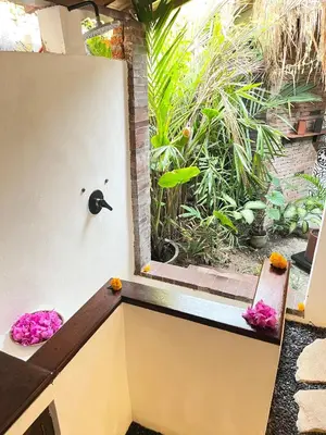 a room with a window with a bench and flowers at My Secret Home in Seminyak