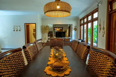 a dining room with a wooden table and chairs at Villa MARIE - KUTA - 6 Bedroom 4 Bathroom Villa - Great Location ! in Kuta