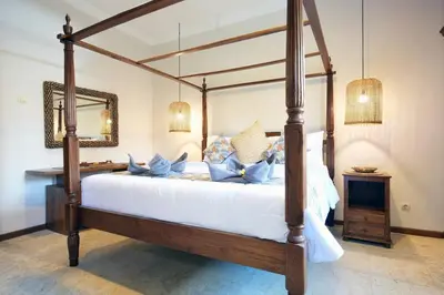 a bedroom with a canopy bed with blue pillows at Villa MARIE - KUTA - 6 Bedroom 4 Bathroom Villa - Great Location ! in Kuta
