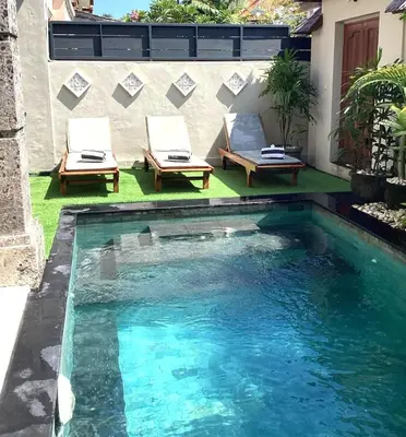 a swimming pool with two loungers and chairs next to a building at Villa MARIE - KUTA - 6 Bedroom 4 Bathroom Villa - Great Location ! in Kuta