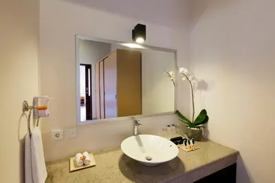 a bathroom with a sink and a large mirror at Kubal Villa and Living Seminyak in Canggu