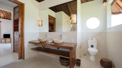 a bathroom with a sink and a toilet at Ku Estate by Villa Finder in Seminyak