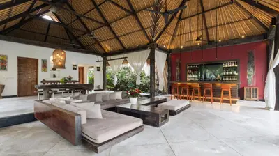 a bar in a resort with couches and a bar at Ku Estate by Villa Finder in Seminyak