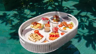 a white table with plates of food on it at Ku Estate by Villa Finder in Seminyak