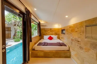a bedroom with a bed next to a swimming pool at Villa Belharra in Seminyak