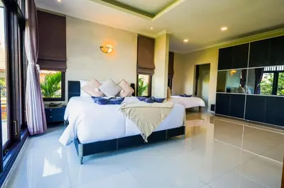 a bedroom with a large bed with white sheets and pillows at Villa LOGAN - KUTA - 5 Bedroom - 3 Bathroom Villa - Great Location in Kuta