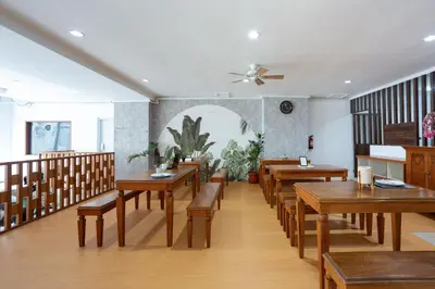 a restaurant with wooden tables and chairs and a fan at Cove De Tinaya in Legian