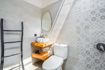 a bathroom with a toilet and a sink and a mirror at The R Villa Kaba - incl. Motorbikes in Seminyak