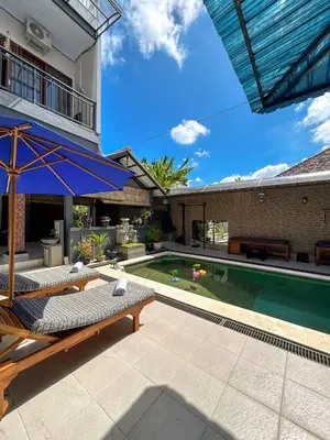 a backyard with a swimming pool and a house at James Guest House in Seminyak