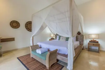 a bedroom with a white bed with a canopy at Villa Budha 1: 4bedrs 12m Pool, 700m2 garden with BBQ in Seminyak