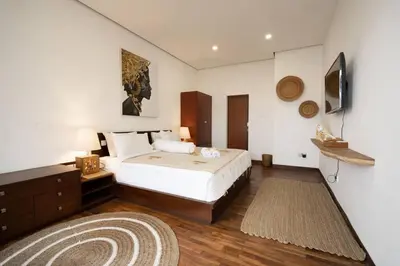 a bedroom with a bed and a television and a rug at Villa Kainara 2 - Cozy villa in center of Seminyak in Seminyak