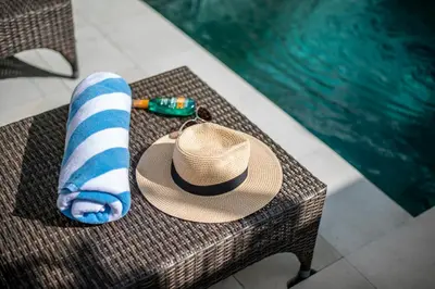 a straw hat and a towel on a wicker bench at Villa Balik I Seminyak in Seminyak