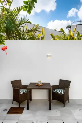 a wooden table and two chairs on a patio at Villa Balik I Seminyak in Seminyak