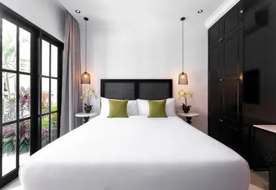 a bedroom with a large white bed and large windows at Martini Beachside Villa 1 in Canggu