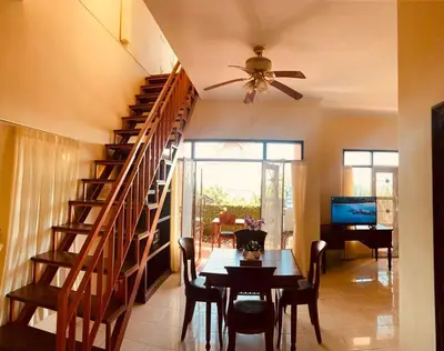a dining room with a table and a spiral staircase at Giri's Villa Jimbaran in Jimbaran