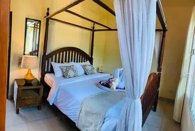 a bedroom with a large bed with a canopy at Giri's Villa Jimbaran in Jimbaran
