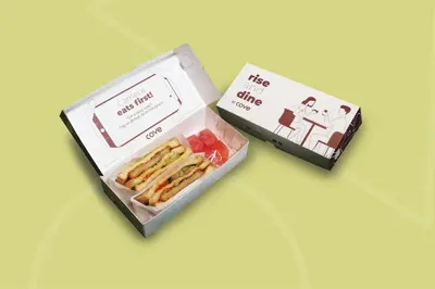 two boxes of food sitting on top of a table at Cove Ransha Stay in Sanur