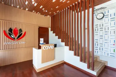 a lobby of a company with a cvg sign and stairs at Cove Ransha Stay in Sanur