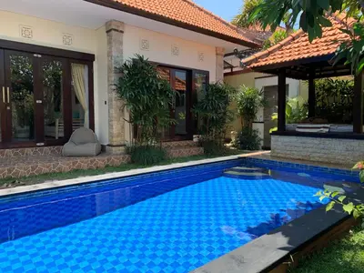 a swimming pool in front of a house at Villa Olga in Seminyak