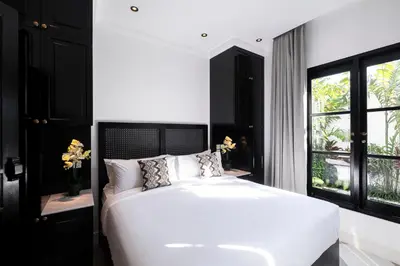 a bedroom with a large white bed and a window at Martini Beachside Villa 4 in Canggu