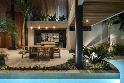 a patio with a table and chairs and a pool at Can Maestro Bali by House of Winds - Lush Sanctuary near Canggu in Kerobokan