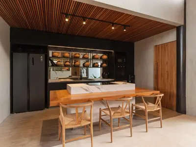 a kitchen with a wooden table and chairs at Can Maestro Bali by House of Winds - Lush Sanctuary near Canggu in Kerobokan