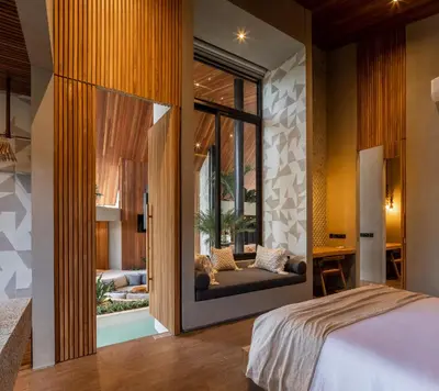 a bedroom with a large glass door leading to a living room at Villa FEH Bali by House of Winds - Neo Tropical Eden near Canggu in Kerobokan
