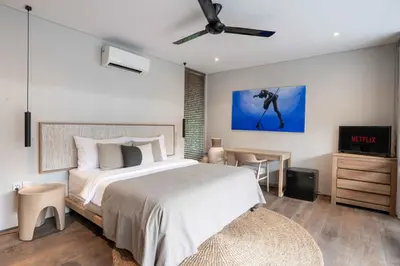a bedroom with a bed and a flat screen tv at Sin Nombre Bali - Sauna, Ice Bath & Roof Terrace in Canggu