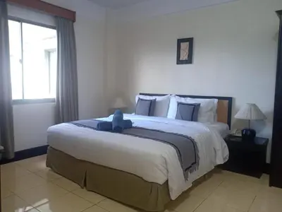 a bedroom with a large bed with a blue teddy bear on it at Kun's Stay Private Apartments in Seminyak