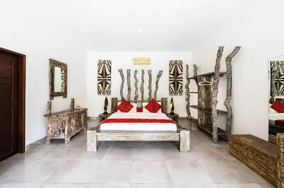 a bedroom with a bed with red pillows on it at Villa Permata Umalas - Relaxing Tropical Oasis in Seminyak