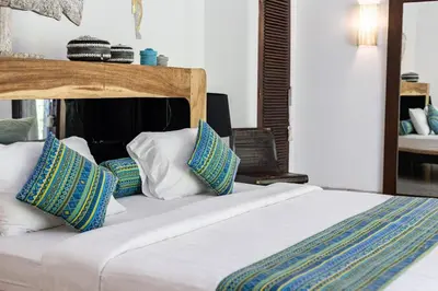 a bedroom with a large bed with blue and white pillows at Villa Permata Umalas - Relaxing Tropical Oasis in Seminyak