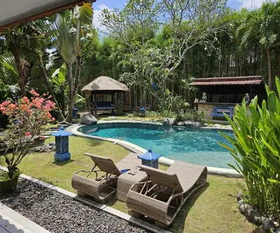 a swimming pool with two chairs and a gazebo at Villa Permata Umalas - Relaxing Tropical Oasis in Seminyak