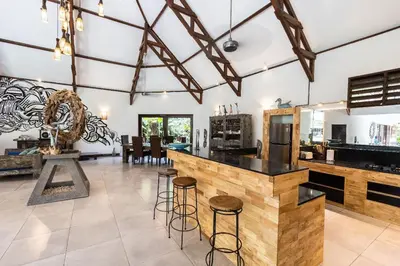 a kitchen and dining room with a counter and stools at Villa Permata Umalas - Relaxing Tropical Oasis in Seminyak