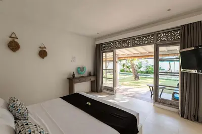 a bedroom with a bed and a large window at Villa Nyama by Optimum Bali Villas in Seminyak