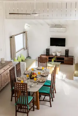 a dining room with a table and chairs and a television at Villa Nyama by Optimum Bali Villas in Seminyak