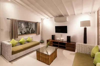 a living room with a couch and a tv at Villa Nyama by Optimum Bali Villas in Seminyak