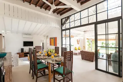 a dining room with a table and chairs and a living room at Villa Nyama by Optimum Bali Villas in Seminyak